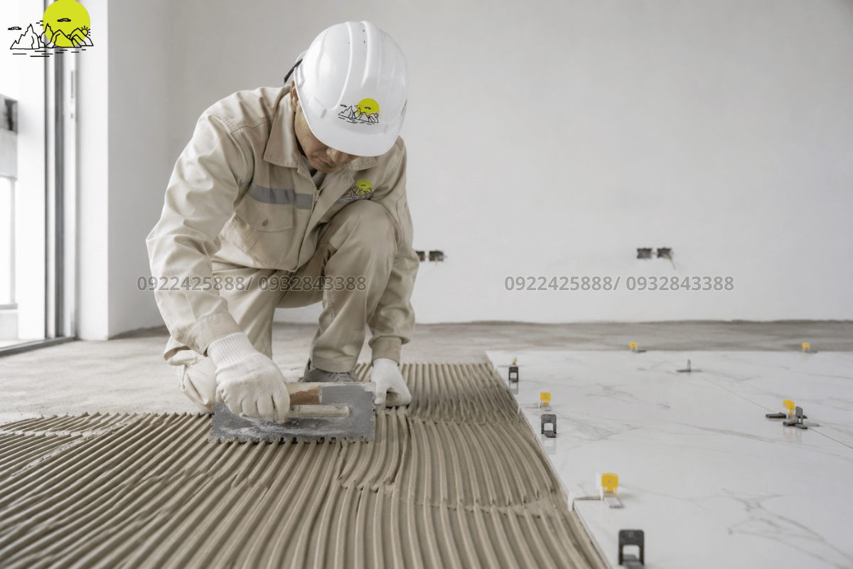 Thợ thi công sử dụng bay răng cưa chuyên dụng để trải đều keo dán đá
